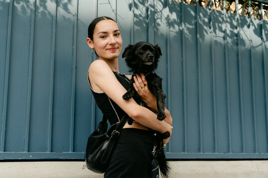 portrait of happy stylish woman in the street with her dog