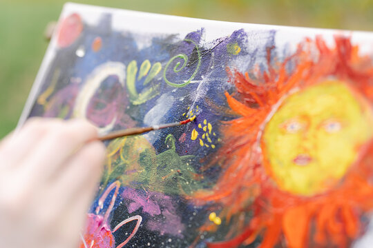 hand of young artist painting on canvas