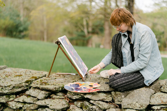 teen artist painting on canvas