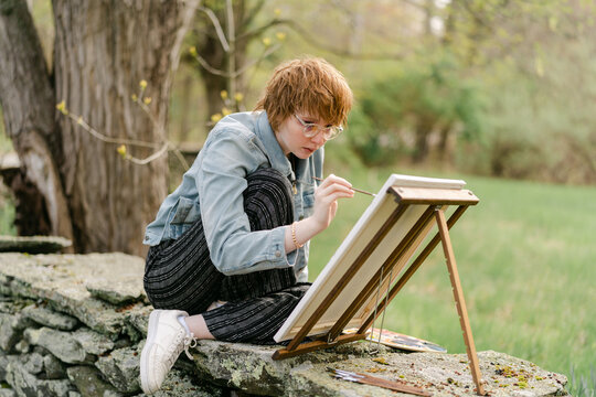 teen artist painting on canvas