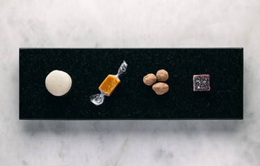Petit four delicatessen in rack on black marble board table