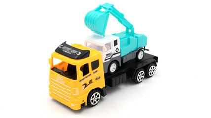 Toy truck with trailer transports excavator on white background.