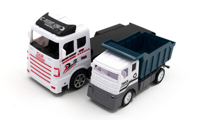 Toy truck with trailer transports dumper on white background.