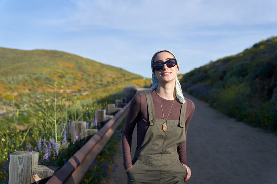 Pretty muslim girl in nature with sunglasses and overalls