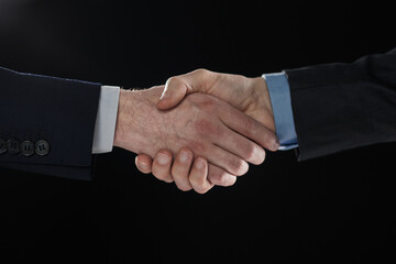 Men shaking hands. Confident businessman shaking hands on black background