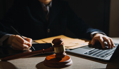 Business and lawyers discussing contract papers with brass scale on desk in office. Law, legal services, advice, justice and law concept picture with film grain effect