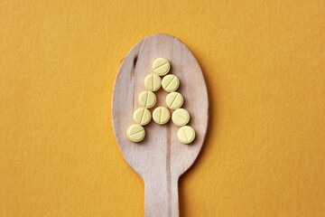 The letter A on a wooden spoon. Vitamin A in food, vitamin A deficiency