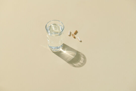 Glass of water and moringa capsule pills