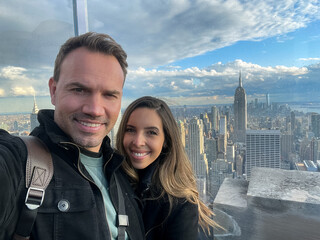couple taking selfie standing against cityscape on high