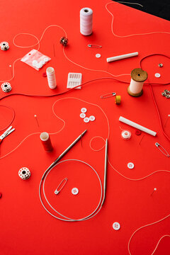 Sewing items scattered on red
