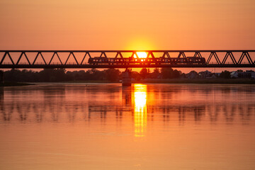 Fototapeta na wymiar Sonnenuntergang an der Eisenbahnbrücke über die Elbe bei Wittenberge