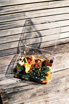 container with some food on a boardwalk, 35mm