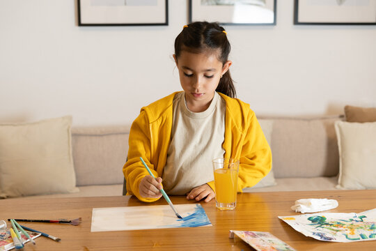 Creative Inspiration. Girl in Yellow Hoodie Painting with Watercolors.