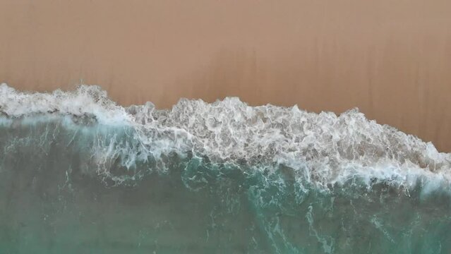 Top aerial view from above ocean foam waves rolling on sand beach at tropical beach. Copy space for your advertising text message or promotional content. 