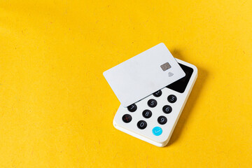 A white credit card on a white wireless terminal payment