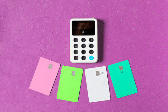 Credit cards below a white wireless terminal 