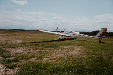 Fototapeta na wymiar Glider plane preparing to take off surrounded by mountains in Nowy Targ, Zakopane in Poland. The sky and the view are visible in the background