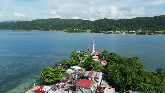 Aerial parallax around light house lookout and fishing village homes in catanduanes