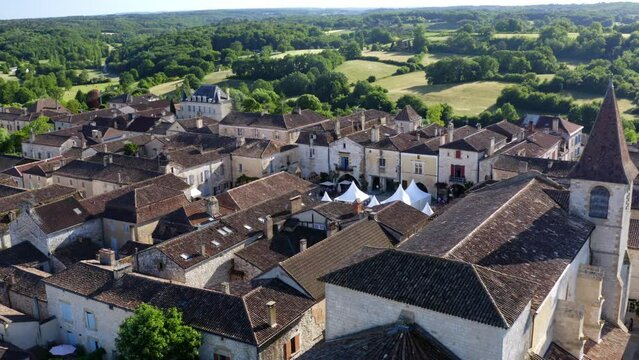 The church and square of Monpazier during a cultural event, white stands for exhibitors are in the center of the square, Dordogne, France