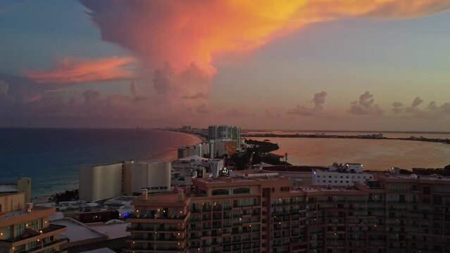 An exquisite aerial dolly shot capturing the serene sunset over Punta Cancun, Mexico. The cinematic view highlights the breathtaking Caribbean horizon during sunset, showcasing Cancun's coastal beauty