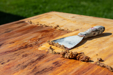 Removing the old paint with a trowel, renovation works