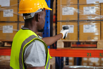 African american male worker factory holding a barcode scanner doing scan barcodes to count...
