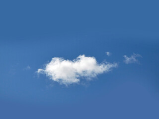 Single white cloud over blue sky background. Fluffy cumulus cloud shape