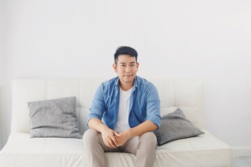 Asian man sitting on sofa