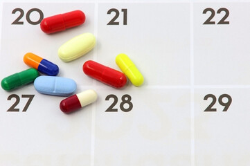 Pills or medications on the days of a paper calendar. Medication adherence