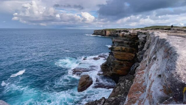 4k Video -Spectacular view from above of waves splashing on the sandstone cliffs on the coast on the scenic Cape Baily Track at Kurnell in Kamay National Park, Sydney, Australia.