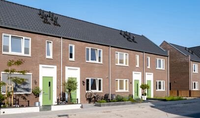 Dutch Suburban area with modern family houses, newly build modern family homes in the Netherlands, dutch family house in the Netherlands, Street with modern family houses in urban suburb  - obrazy, fototapety, plakaty