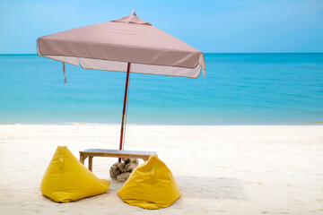 Fototapeta na wymiar Beautiful view of tropical beach, Thailand. Yellow beach bed, bean bag chair and umbrella on white sand for relaxing looking out over the blue sea ocean. Rest in the holiday concept. 