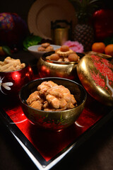 Chinese new year festival freshly baked assorted crispy cookies set with pineapple tart, almond, chocolate , coconut walnut, peanut and spicy shrimp floss roll in luxury asian red gold platter design