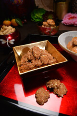 Chinese new year festival freshly baked assorted crispy cookies set with pineapple tart, almond, chocolate , coconut walnut, peanut and spicy shrimp floss roll in luxury asian red gold platter design