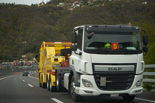 13.04.2023 Switzerland, Europe. Truck towing truck. Truck carrying semi-truck on the highway