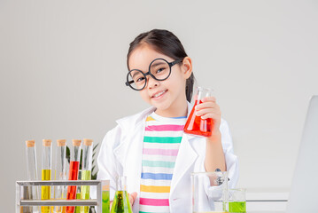 Asian little girl working with test tube science experiment in white classroom