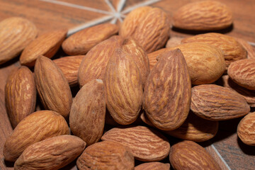 Almonds on brown wooden background