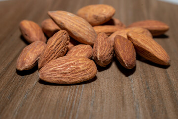 Almonds on brown wooden background
