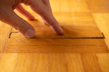 Old damaged parquet with loose strips (strip parquet) is examined by a specialist before it is reconditioned by re-sanding.