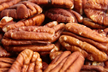 Pecan nuts kernel texture background closeup. Heap of peeled pecan halves. Pecan halves, a puzzle of nutty goodness