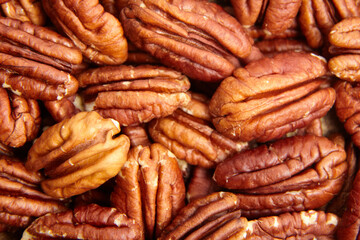 Pecan nuts kernel texture background closeup. Heap of peeled pecan halves. Pecans, a mosaic of...