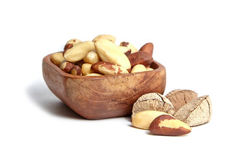 Brazil nuts in wooden bowl isolated on white background. Closeup of Brazil nuts kernel goodness