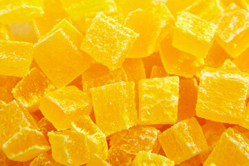 Diced mango dried fruits texture background, top view. Dehydrated mango chips dices, sweet food closeup