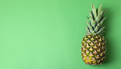 Whole ripe pineapple on light green background, top view. Space for text