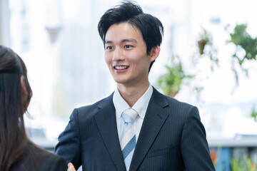 オフィスで話す新人ビジネスマン男女