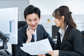 オフィスで話す新人ビジネスマン男女