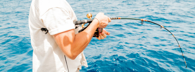 Angler hält die Angel ins Wasser