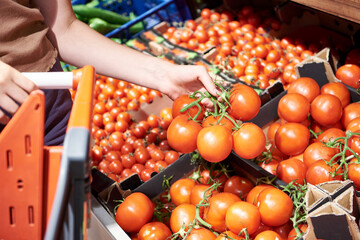 Tomatoes in hands of buyer in shop