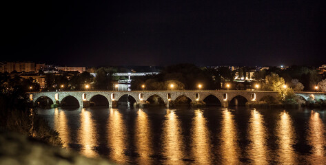 Fototapeta na wymiar Stone Bridge in Zamora, Spain, over the Duero River, illuminated at night