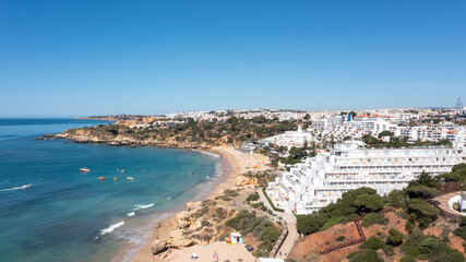 Fototapeta na wymiar Aerial photo of the beautiful town in Albufeira in Portugal showing the Praia da Oura golden sandy beach, with hotels and apartment in the town, taken on a summers day in the summer time.